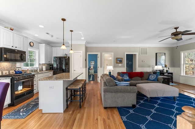 living room with plenty of natural light, light wood-type flooring, and visible vents