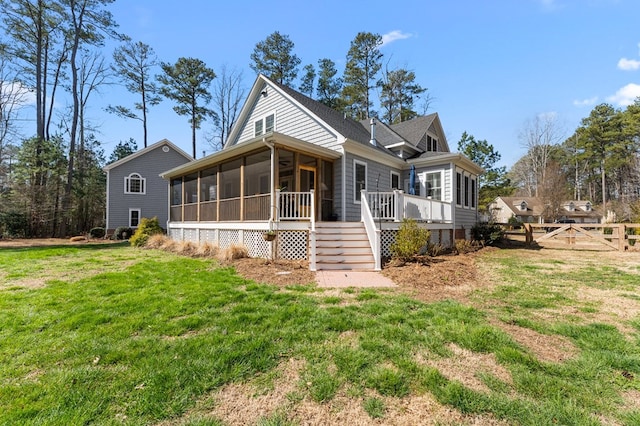 view of front of property featuring a front yard, stairway, fence, and a sunroom