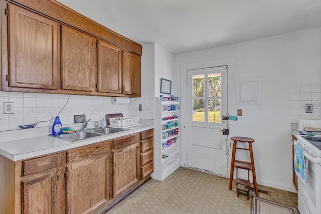 1021 Virmar Beach Rd, Heathsville, VA 22482 - kitchen with a sink, white range with electric stovetop, decorative backsplash, light countertops, and brown cabinets
