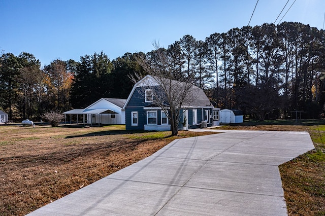 cape cod home with a storage unit and a front yard