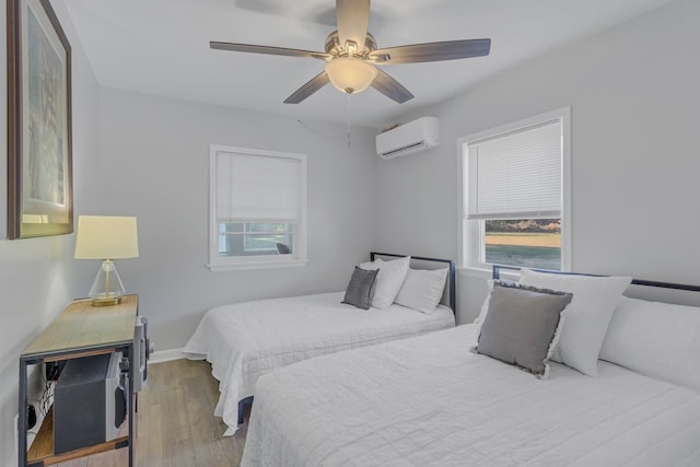 bedroom featuring an AC wall unit, multiple windows, ceiling fan, and hardwood / wood-style floors