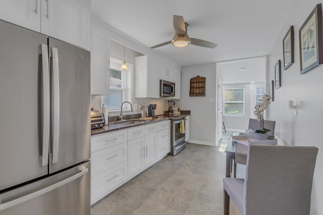 kitchen with ceiling fan, white cabinetry, sink, and appliances with stainless steel finishes