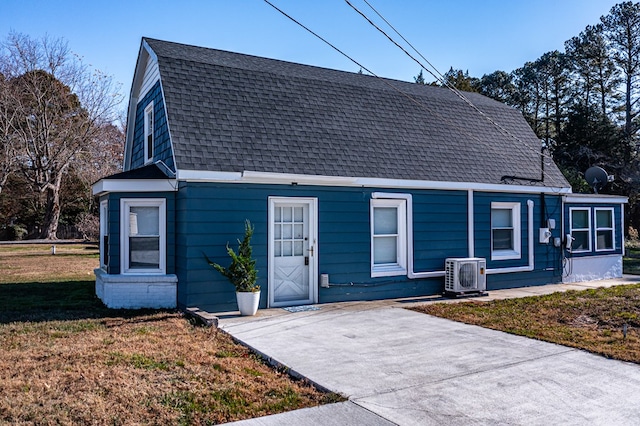 view of front facade with ac unit and a front lawn