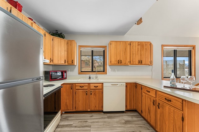 kitchen featuring sink, white appliances, and light wood-type flooring