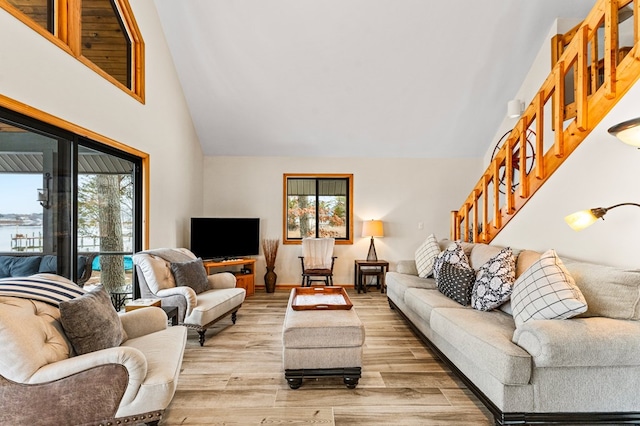 living room with light hardwood / wood-style floors and high vaulted ceiling