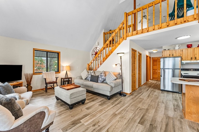 living room featuring light wood-type flooring and high vaulted ceiling