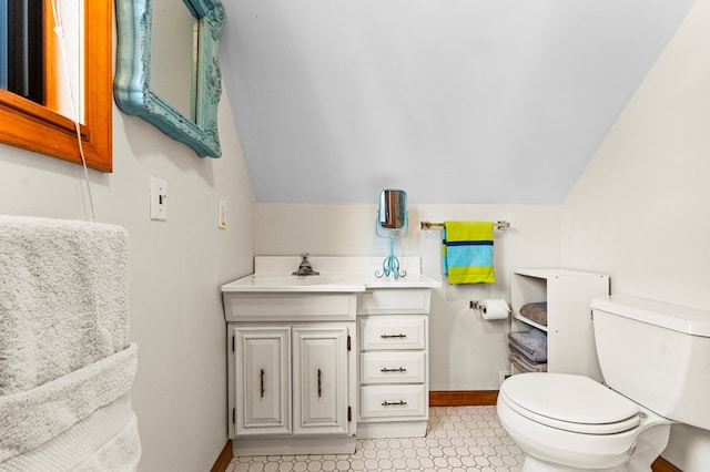 bathroom with vanity, toilet, and lofted ceiling