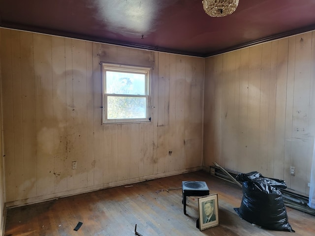 unfurnished room featuring wood-type flooring and wooden walls