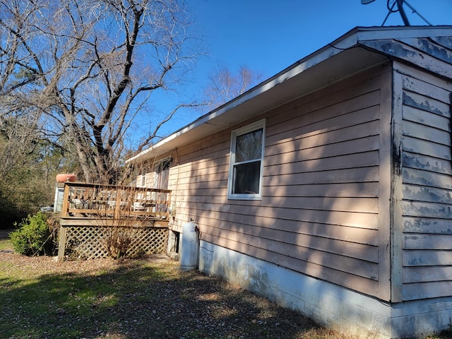 view of property exterior with crawl space and a deck