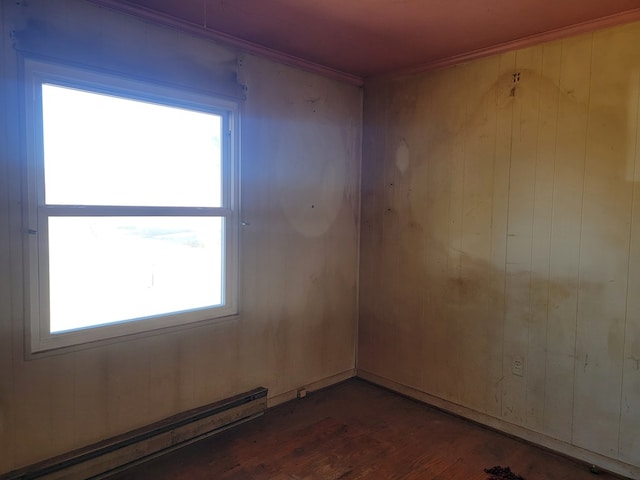 spare room with baseboard heating and wood finished floors