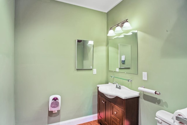 bathroom with vanity, toilet, and wood-type flooring