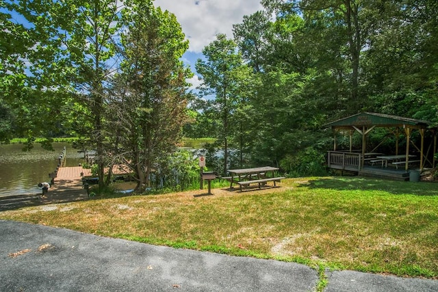 view of home's community featuring a gazebo, a water view, a dock, and a lawn