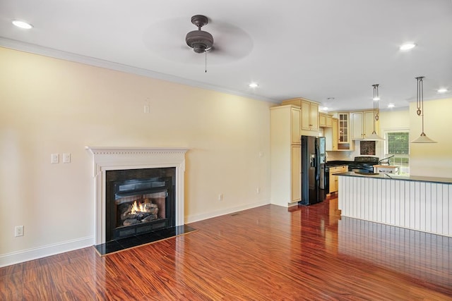 unfurnished living room featuring crown molding, dark hardwood / wood-style flooring, and ceiling fan