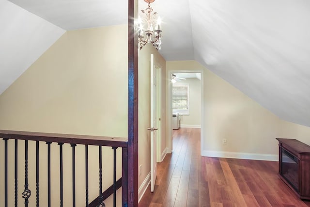 bonus room with ceiling fan with notable chandelier, dark hardwood / wood-style flooring, and lofted ceiling