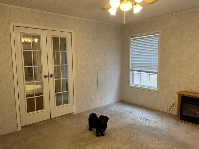 unfurnished living room featuring crown molding, carpet, and french doors