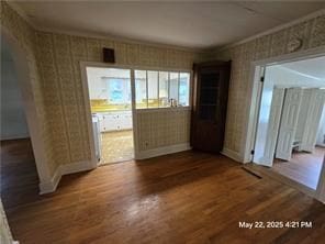 300 Irvington Rd, Kilmarnock, VA 22482 - spare room with wallpapered walls, baseboards, dark wood-type flooring, and ornamental molding