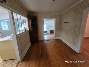 300 Irvington Rd, Kilmarnock, VA 22482 - hallway featuring ornamental molding, wood finished floors, wallpapered walls, and baseboards