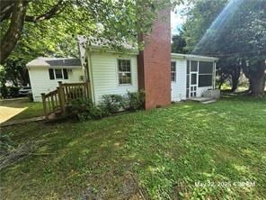 300 Irvington Rd, Kilmarnock, VA 22482 - back of house featuring a chimney, a lawn, and a sunroom