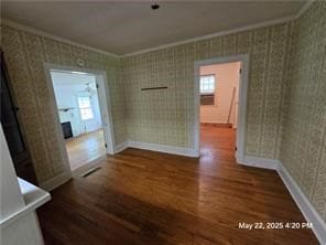 300 Irvington Rd, Kilmarnock, VA 22482 - unfurnished dining area with wood finished floors, crown molding, wallpapered walls, and baseboards