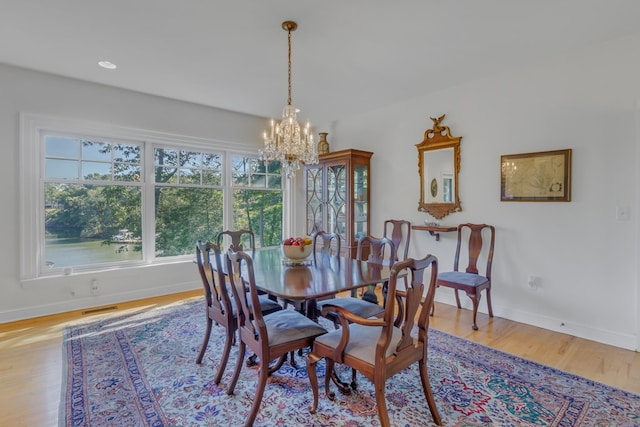 dining room with light hardwood / wood-style flooring and a chandelier