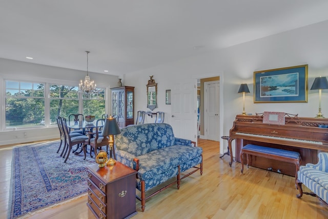 living room featuring light wood-type flooring and a chandelier