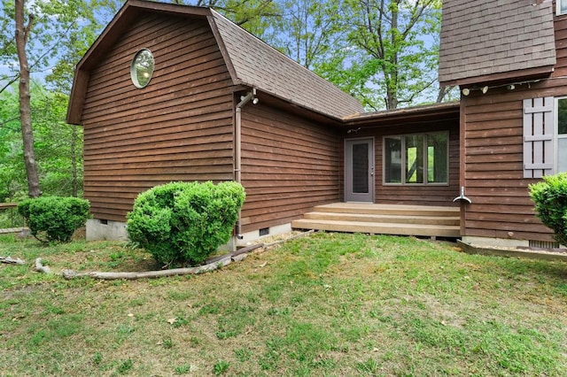 exterior space with a yard, crawl space, and a shingled roof