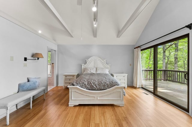 bedroom featuring light wood-type flooring, vaulted ceiling with beams, and access to exterior