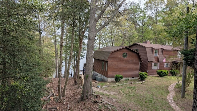 view of side of property with central air condition unit, a chimney, a gambrel roof, and crawl space
