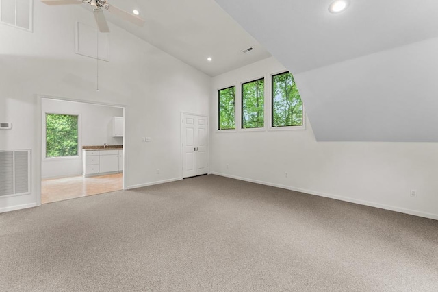 carpeted empty room with visible vents, ceiling fan, high vaulted ceiling, and recessed lighting