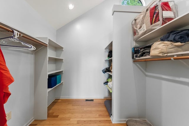 walk in closet with wood finished floors