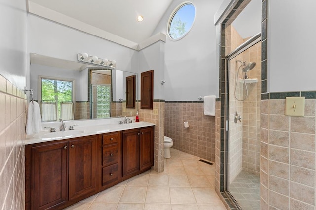 full bathroom with a shower stall, a sink, toilet, tile walls, and tile patterned flooring