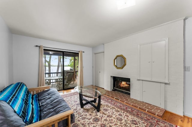 living area with a glass covered fireplace and light wood-type flooring