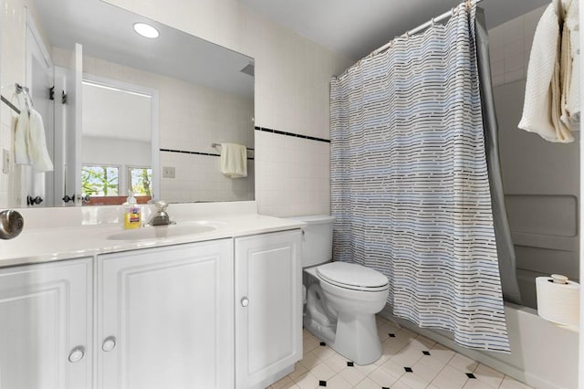 bathroom featuring tile walls, vanity, tile patterned floors, toilet, and shower / tub combo with curtain