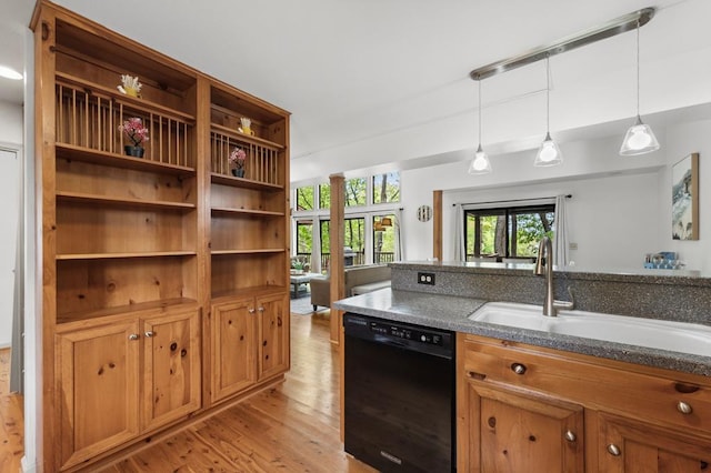 kitchen featuring a sink, light wood-style floors, decorative light fixtures, black dishwasher, and brown cabinetry