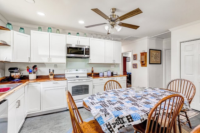 274 Regina Rd, Lancaster, VA 22503 - kitchen with stainless steel microwave, white range with electric stovetop, crown molding, light wood-style floors, and white cabinets