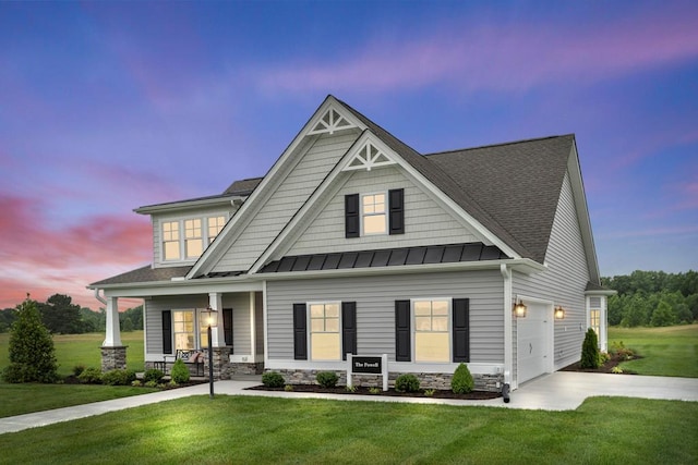 craftsman-style house with a yard, a porch, and a garage