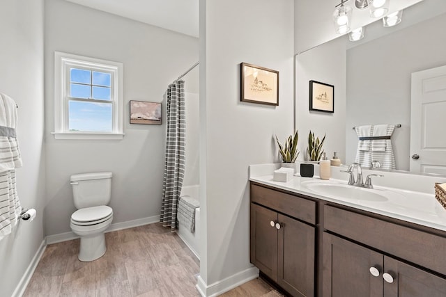 full bathroom with hardwood / wood-style floors, vanity, toilet, and shower / bath combo with shower curtain