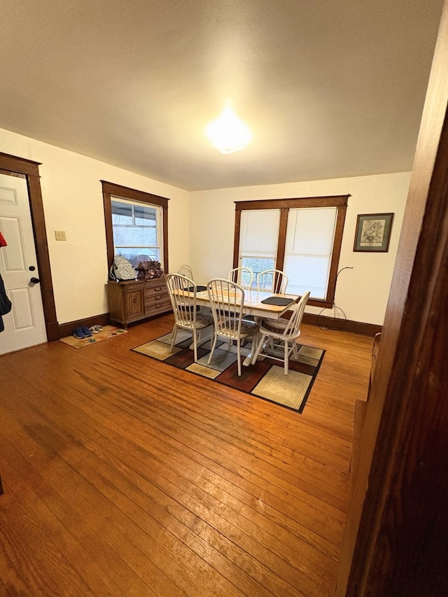 dining room featuring hardwood / wood-style flooring and baseboards