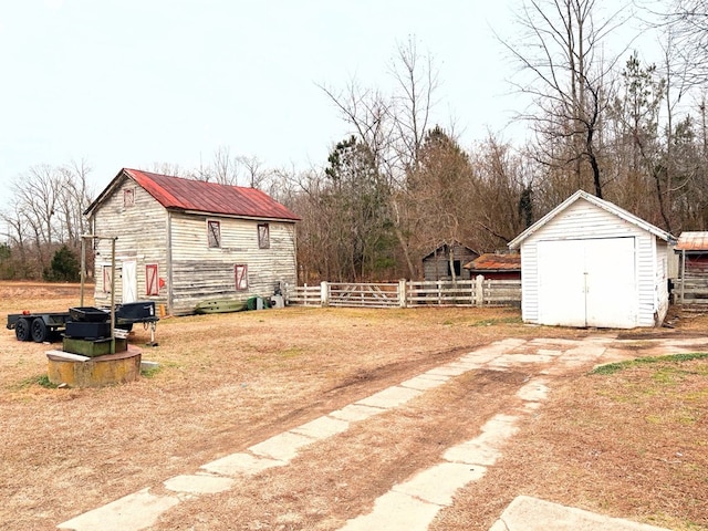 view of yard featuring a storage unit, fence, and an outbuilding