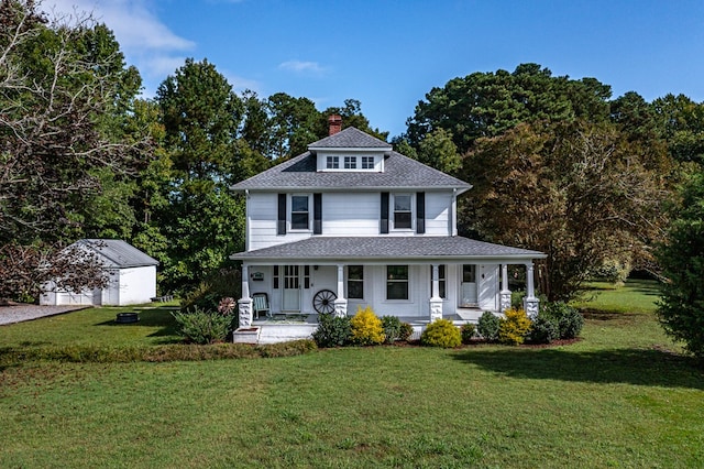 view of front of home featuring covered porch, an outdoor structure, and a front yard