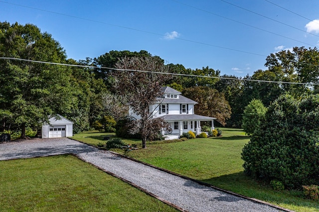 view of front facade featuring a porch, a garage, a front lawn, and an outdoor structure