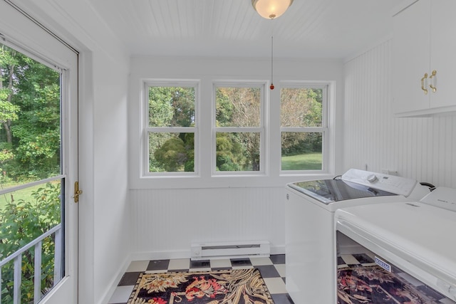 clothes washing area featuring cabinets, baseboard heating, washer and clothes dryer, and plenty of natural light