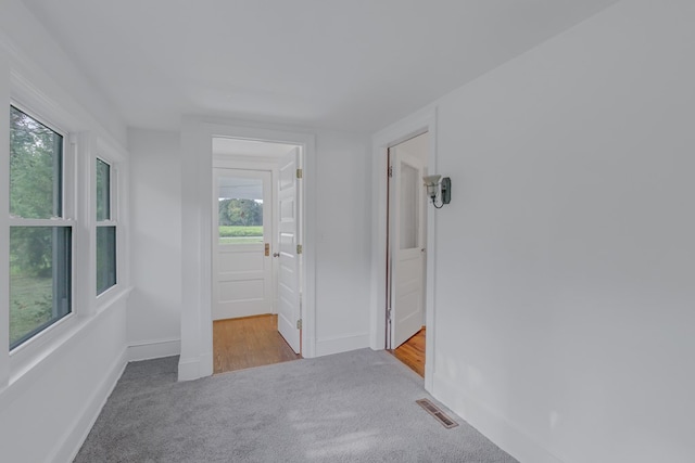 hallway featuring light carpet