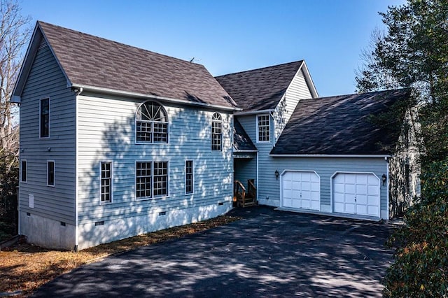 colonial-style house with crawl space, driveway, an attached garage, and roof with shingles