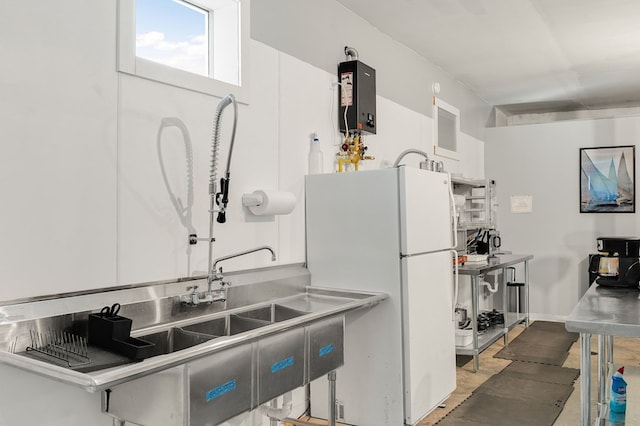 kitchen with white refrigerator, white cabinets, and water heater