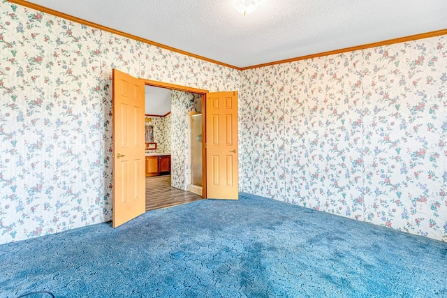 carpeted spare room featuring a textured ceiling and ornamental molding