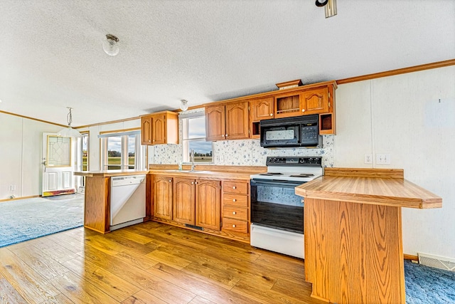 kitchen with sink, light hardwood / wood-style flooring, kitchen peninsula, white appliances, and ornamental molding