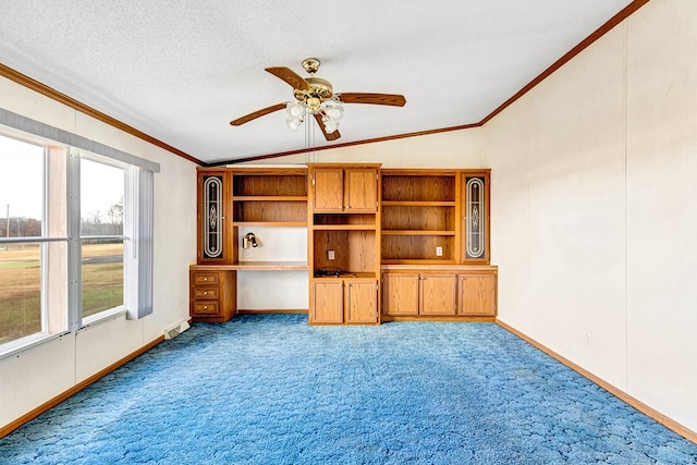 unfurnished living room featuring ceiling fan, carpet floors, lofted ceiling, and ornamental molding