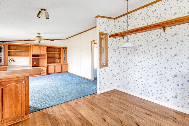 unfurnished living room with crown molding, ceiling fan, light hardwood / wood-style floors, and a textured ceiling