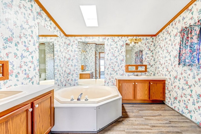 bathroom featuring vanity, a bathtub, a skylight, hardwood / wood-style flooring, and ornamental molding